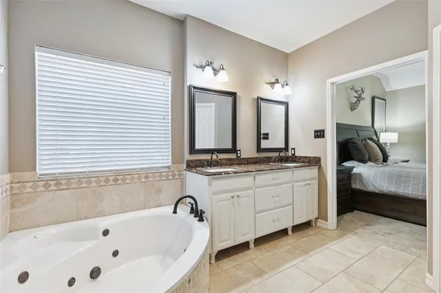 a spacious bathroom with a tub sink and mirror