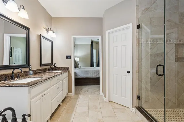 a en suite bathroom with a granite countertop sink mirror and shower