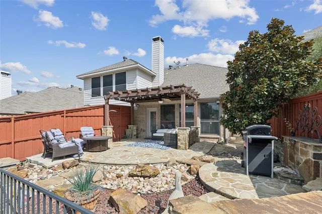 a view of a patio with table and chairs potted plants with wooden floor and fence