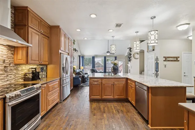 a large kitchen with stainless steel appliances lots of counter space and a sink