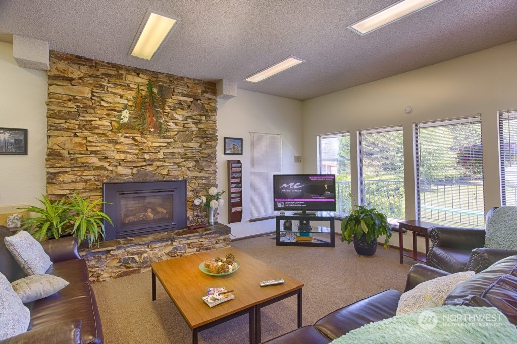 1272 Spruce Drive Enumclaw, WA 98022 - Photo 23 of 23 a living room with furniture a fireplace and a flat screen tv