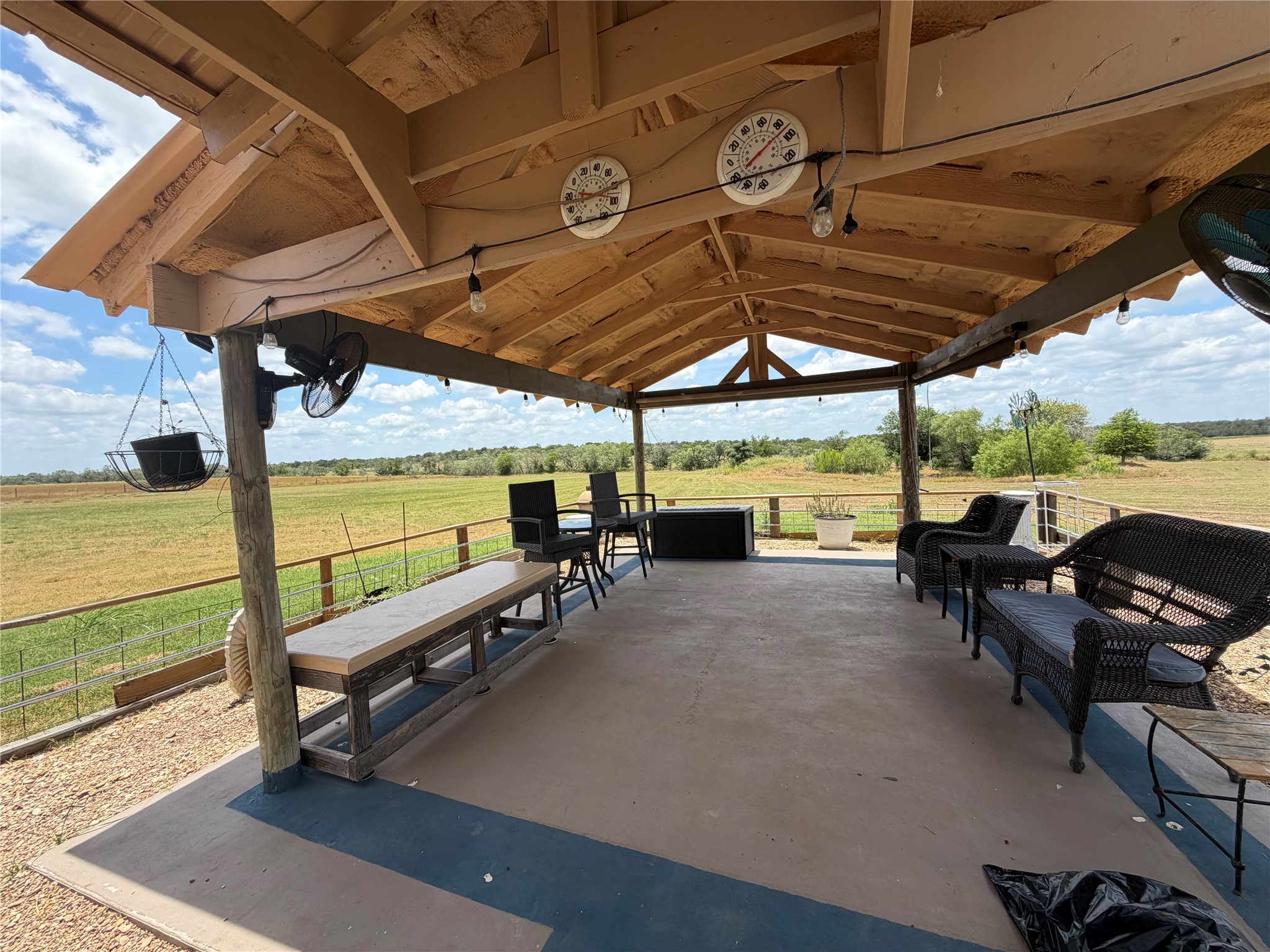 441 Molasses Road Dale, TX 78616 - Photo 6 of 36 An inviting covered patio offers panoramic views of the verdant landscape, perfect for outdoor relaxation.