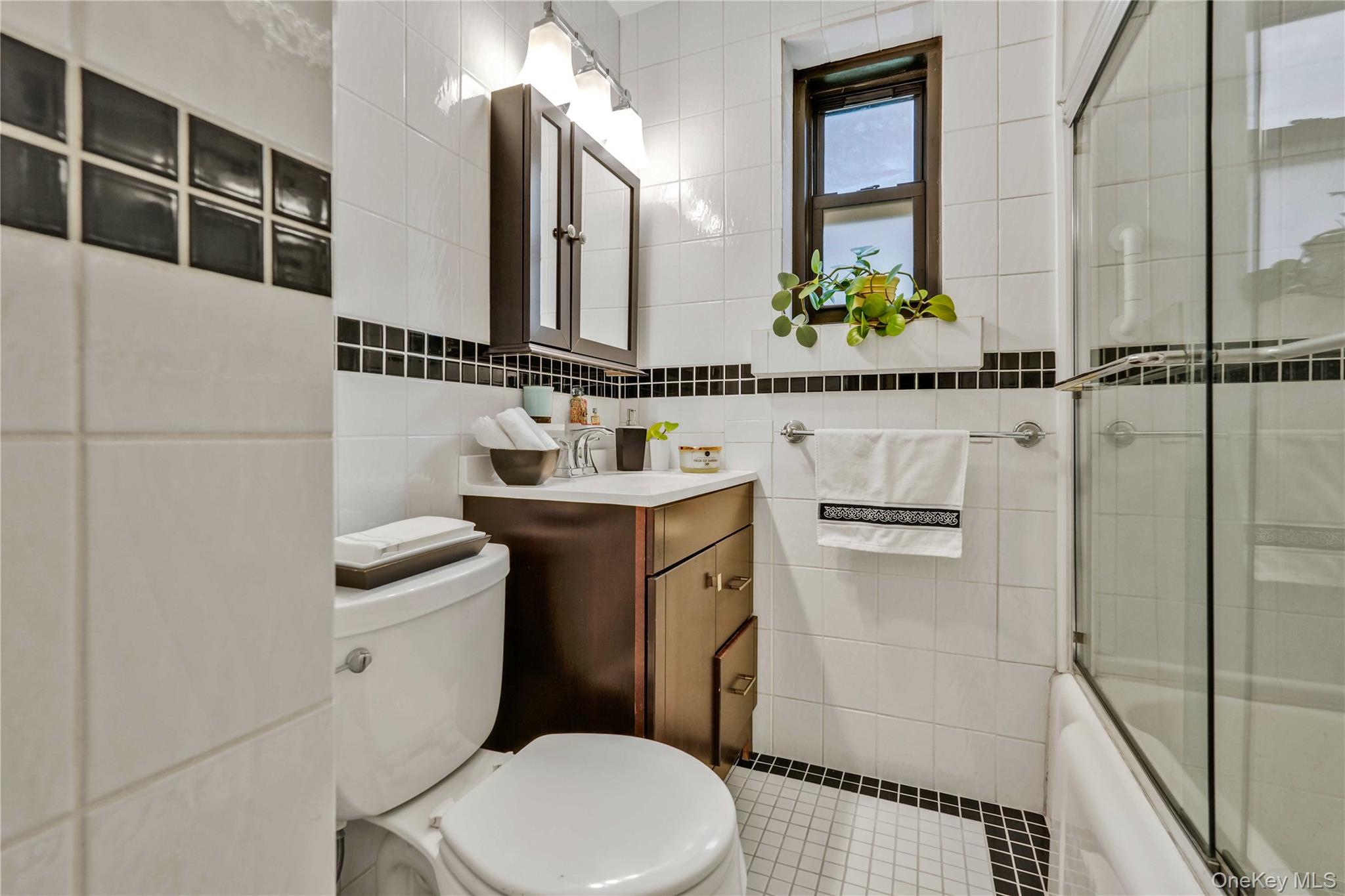 140-08 28th Road, Unit 1C Queens, NY 11354 - Photo 12 of 14 a bathroom with a toilet sink and mirror