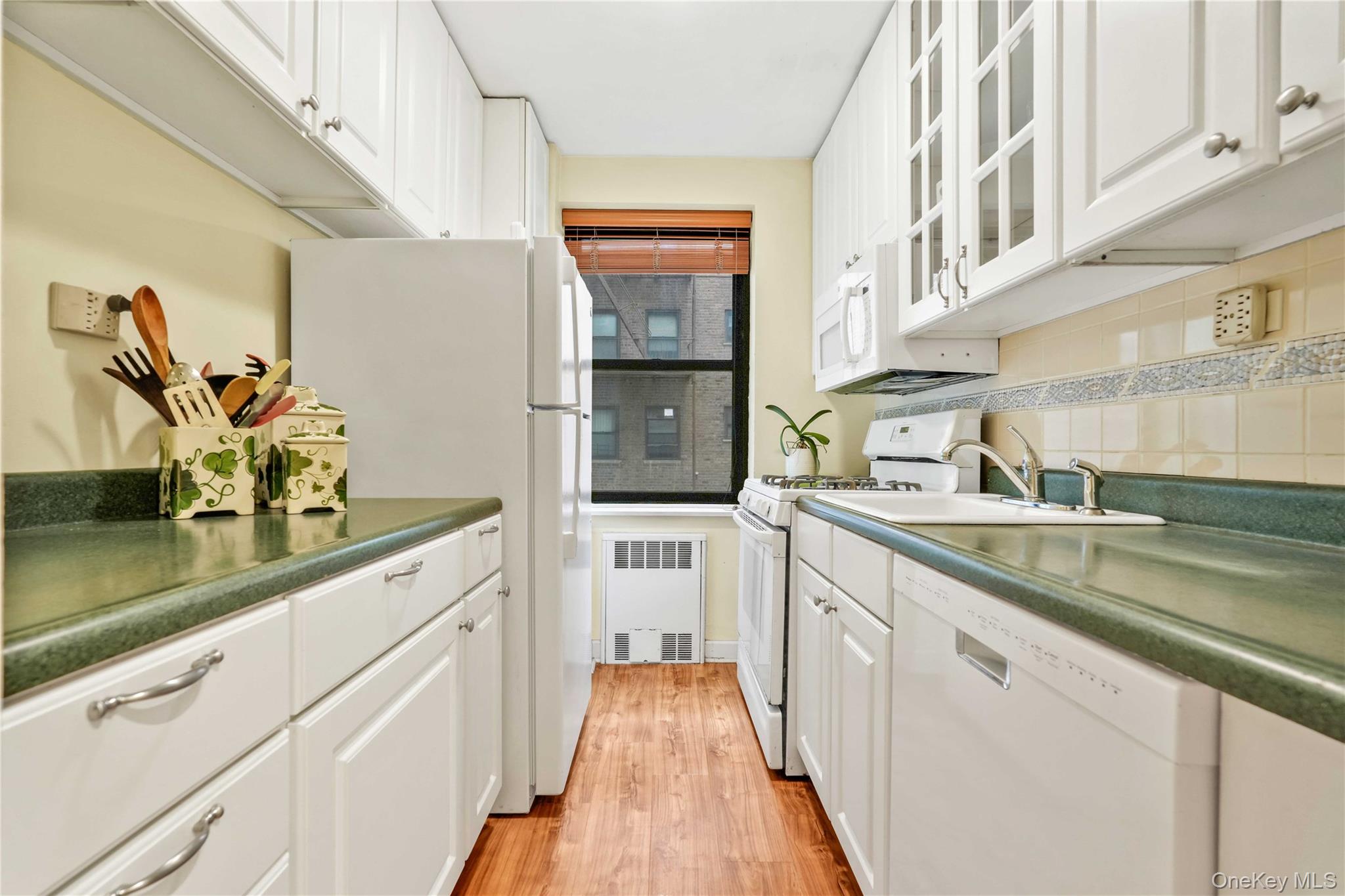 140-08 28th Road, Unit 1C Queens, NY 11354 - Photo 9 of 14 a kitchen with stainless steel appliances granite countertop a sink and dishwasher a stove top oven with wooden floor