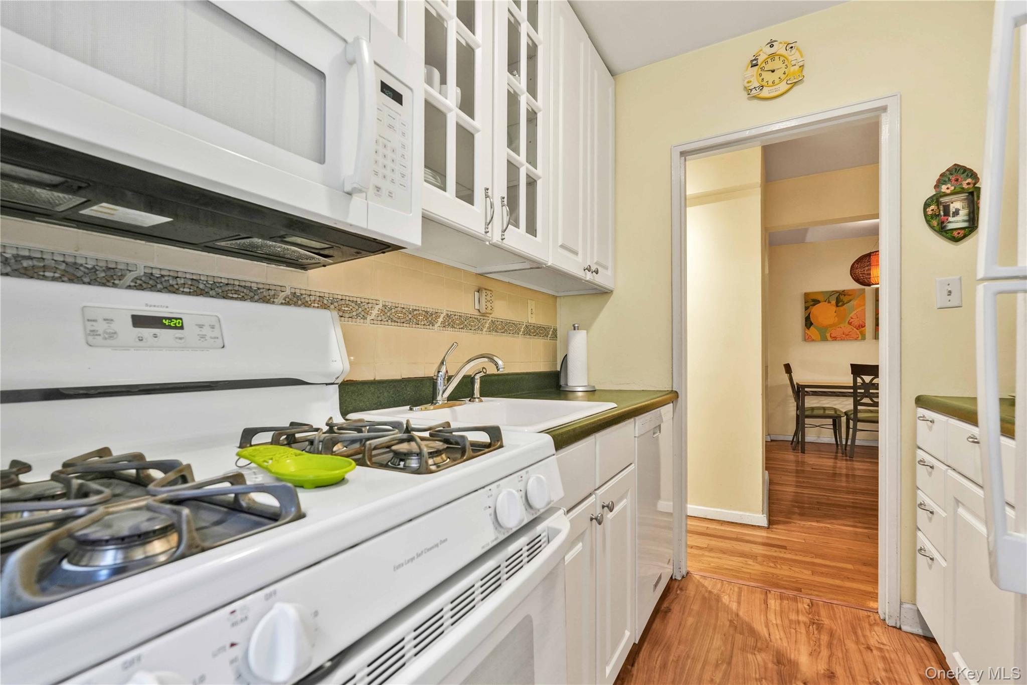 140-08 28th Road, Unit 1C Queens, NY 11354 - Photo 10 of 14 a kitchen with a stove and a wooden floor