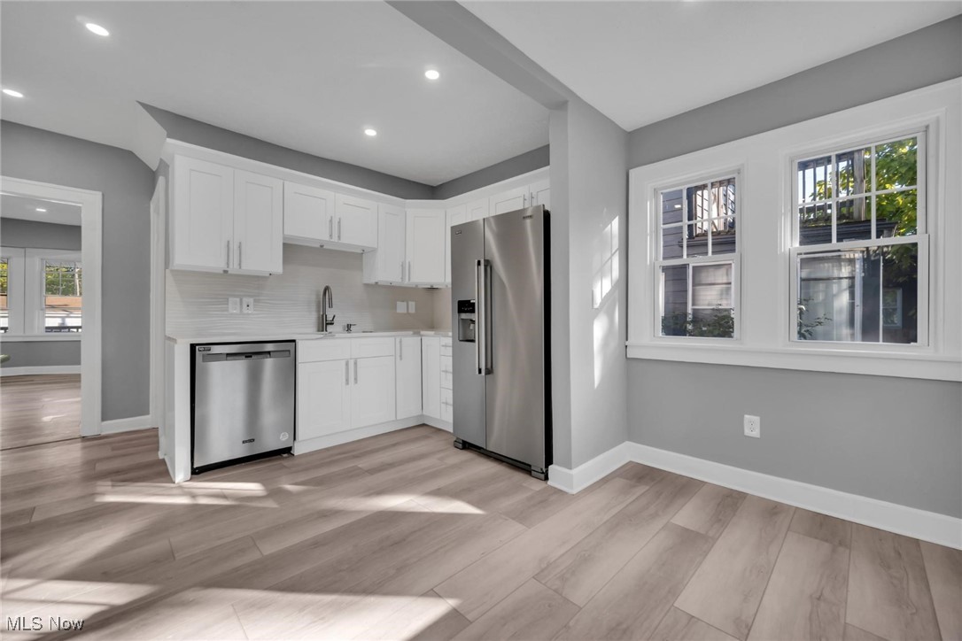 900 Elbon Road Cleveland, OH 44121 - Photo 6 of 29 Kitchen featuring appliances with stainless steel finishes, light wood-type flooring, and white cabinets