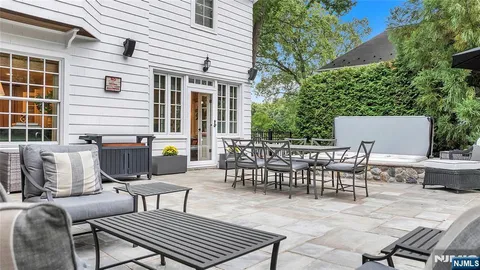 a view of a patio with a dining table and chairs with a fire pit