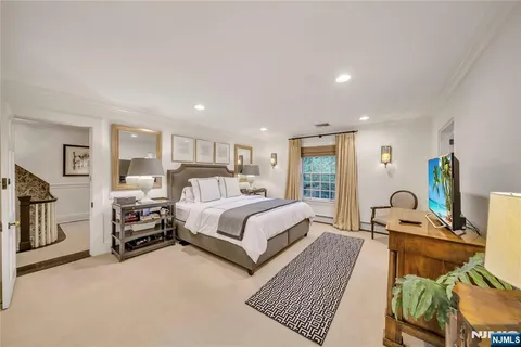 a spacious bedroom with a bed a couch and dresser