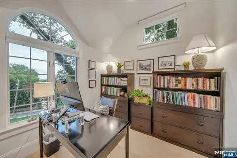 a view of a workspace with furniture and a book shelf
