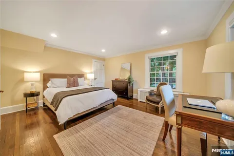 a bedroom with bed and wooden floor