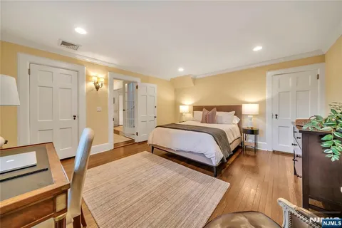 a spacious bedroom with a bed a couch and wooden floor