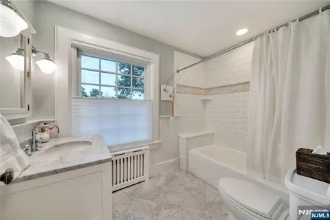 a bathroom with a granite countertop sink a toilet and shower