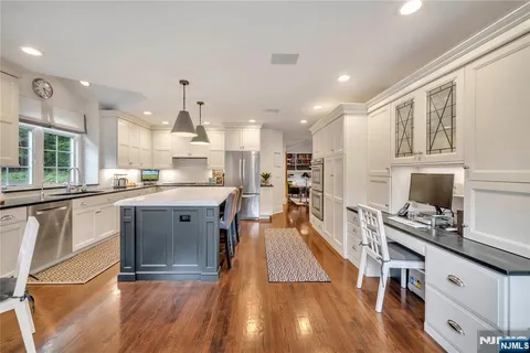 a large kitchen with cabinets wooden floor and stainless steel appliances