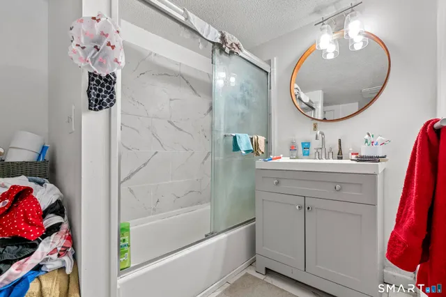 a bathroom with a sink vanity mirror and tub