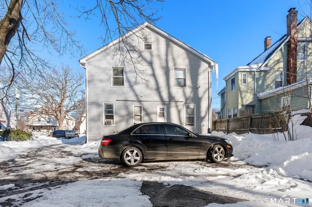a front view of a house with a yard covered in snow