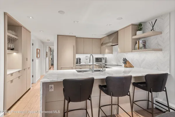 a kitchen with stainless steel appliances granite countertop a sink and a refrigerator
