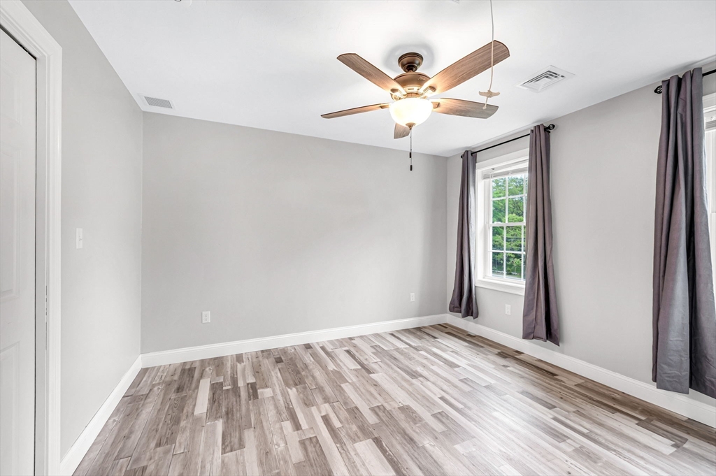 1310 North Brookfield Road Oakham, MA 01068 - Photo 24 of 30 a view of an empty room with wooden floor and a window