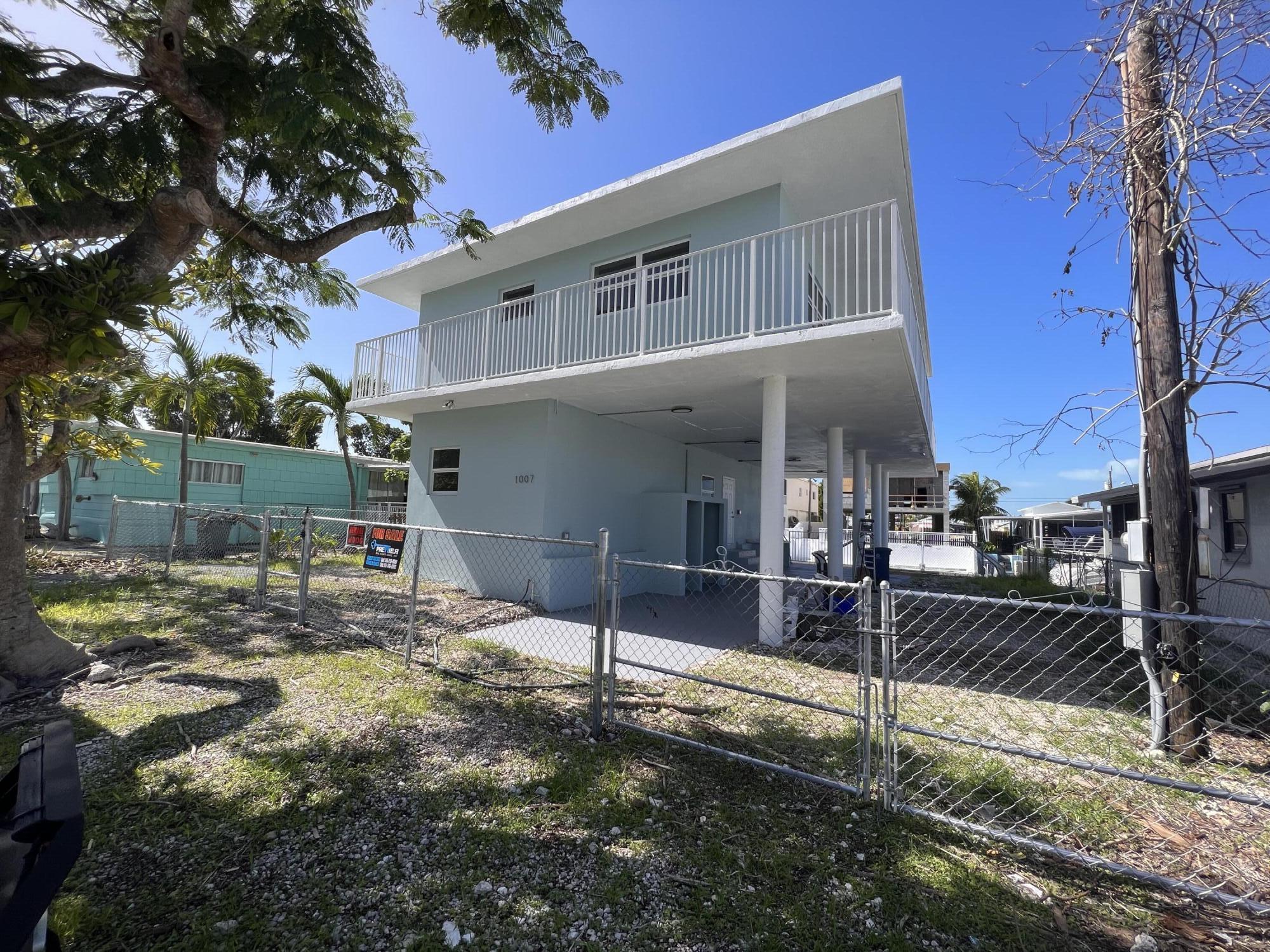 a view of a house with backyard and a tree