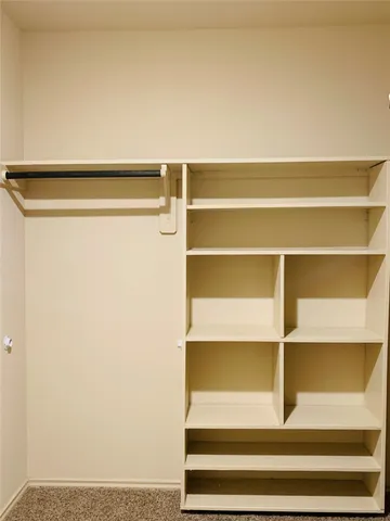 a view of walk in closet with empty racks
