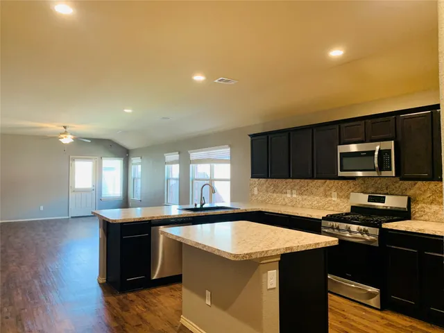 a kitchen with a sink a stove and cabinets