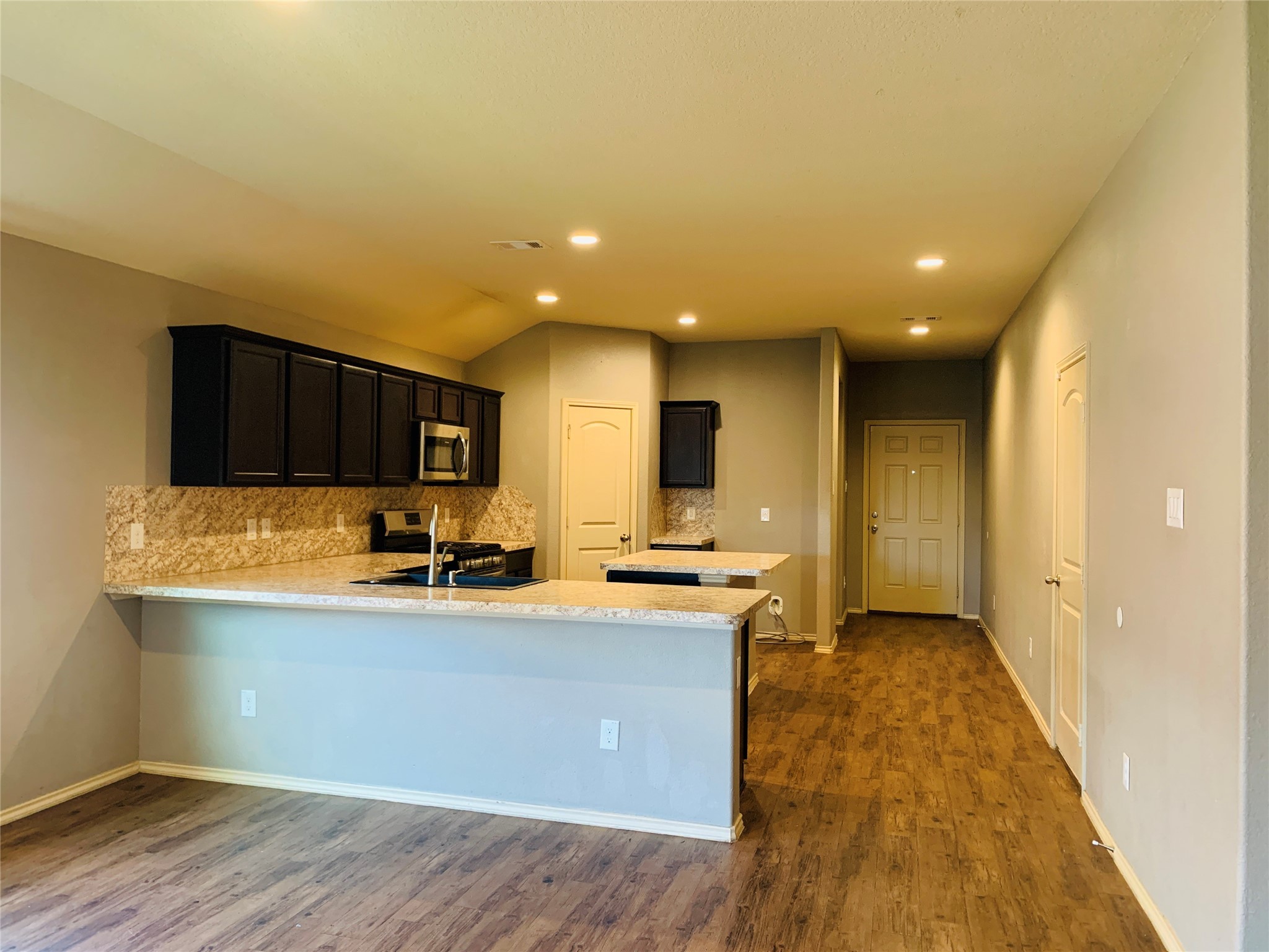15438 Rancho Joya Way Houston, TX 77049 - Photo 8 of 31 a view of a kitchen with kitchen island a sink wooden floor and black appliances