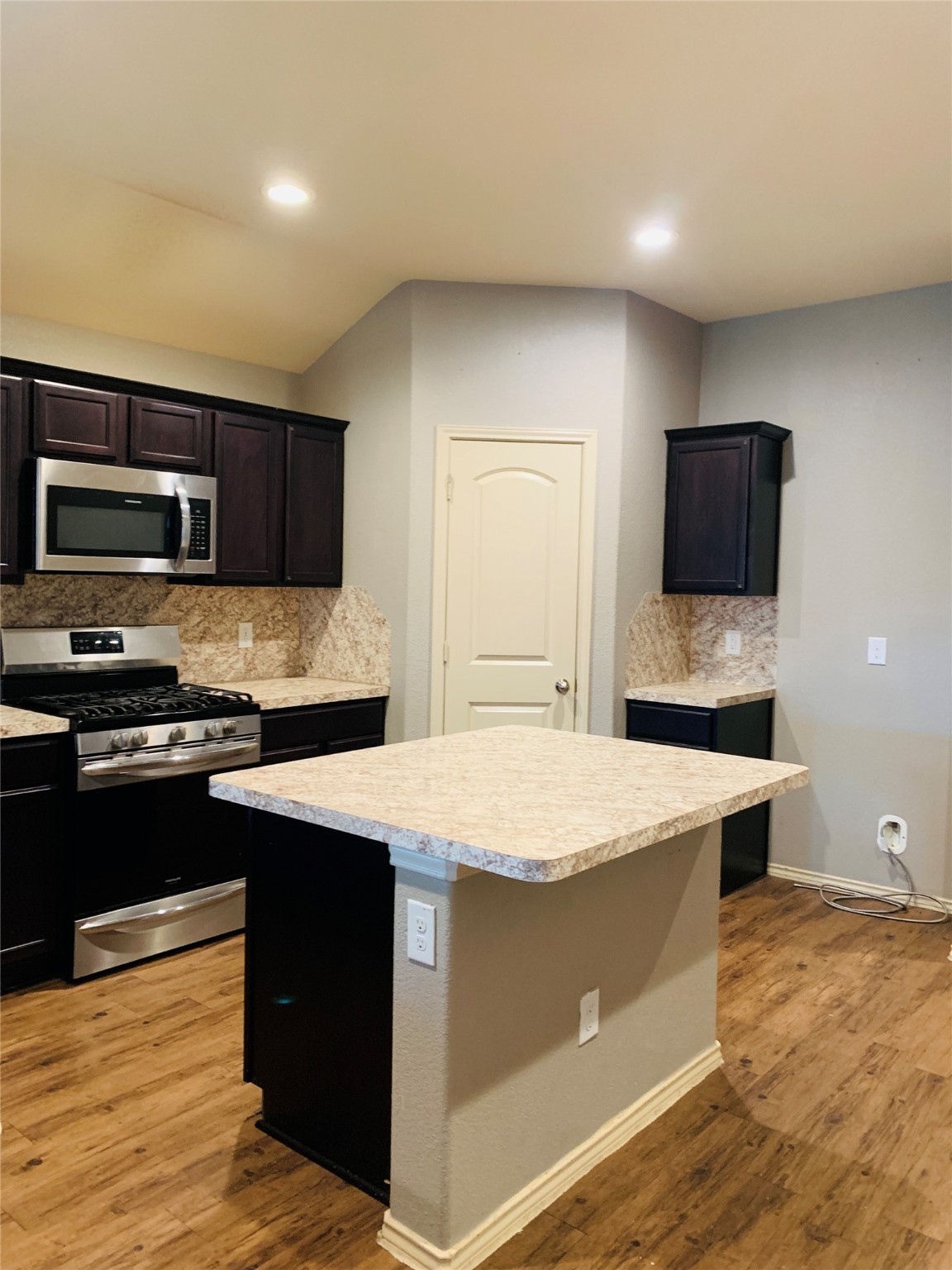 15438 Rancho Joya Way Houston, TX 77049 - Photo 10 of 31 a kitchen with stainless steel appliances granite countertop a stove a sink dishwasher and a microwave with wooden floor