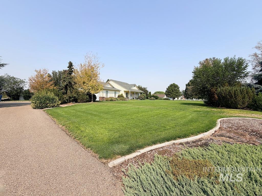 5875 Diamond Ridge Way Nampa, ID 83686 - Photo 5 of 32 Expansive manicured lawn with mature landscaping and established trees, accessed via a curved asphalt driveway