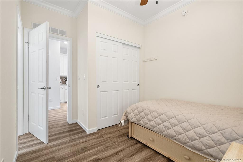 4800 Southeast Federal Highway, Unit 34 Stuart, FL 34997 - Photo 16 of 47 a bedroom with a bed and wooden floor