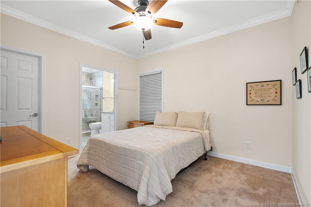 4800 Southeast Federal Highway, Unit 34 Stuart, FL 34997 - Photo 19 of 47 a bedroom with a bed and a chandelier