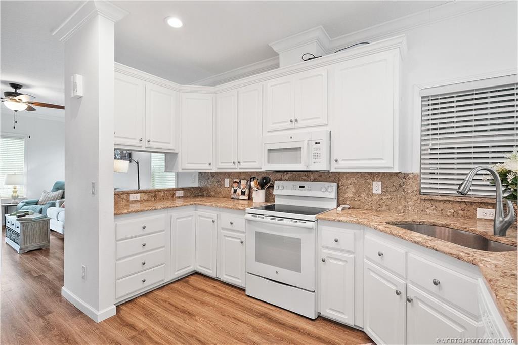 4800 Southeast Federal Highway, Unit 34 Stuart, FL 34997 - Photo 8 of 47 a kitchen with white cabinets white appliances and sink