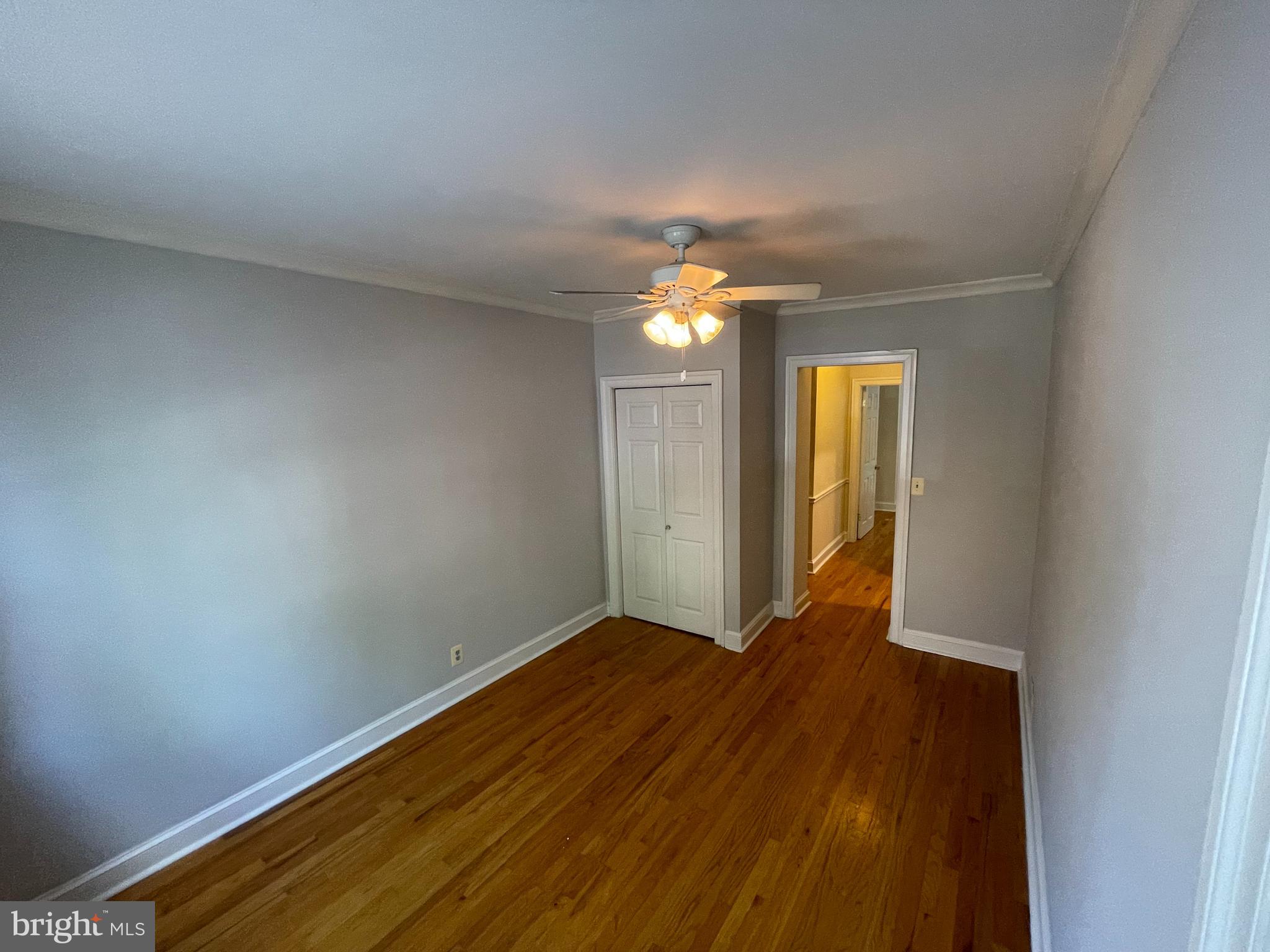 a view of empty room with window and chandelier fan