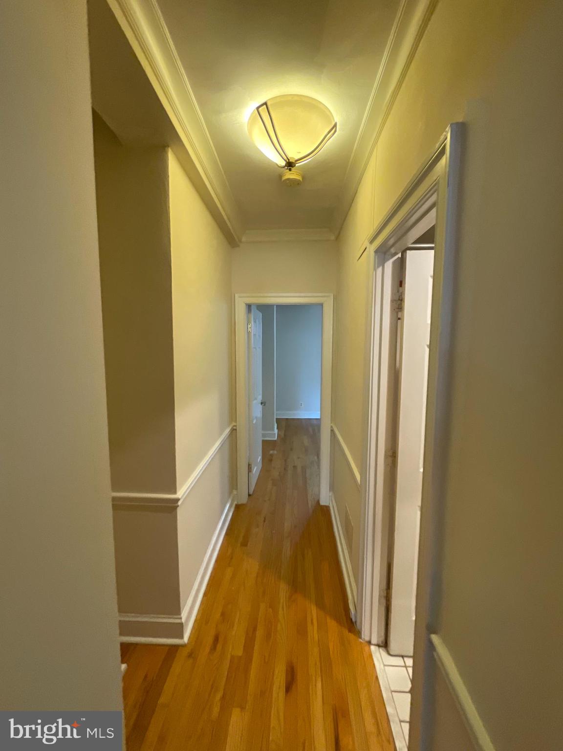 1820 Swann Street Northwest, Unit 101 Washington, DC 20009 - Photo 13 of 15 a view of a hallway with wooden floor and a bathroom