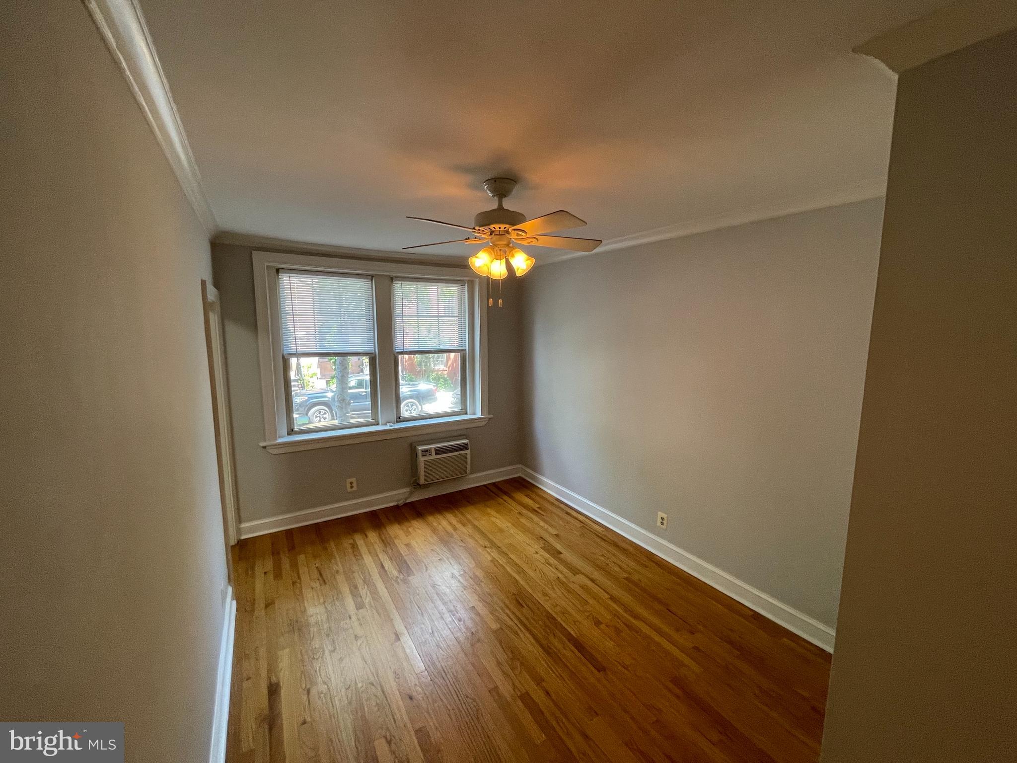 1820 Swann Street Northwest, Unit 101 Washington, DC 20009 - Photo 2 of 15 an empty room with windows and chandelier fan