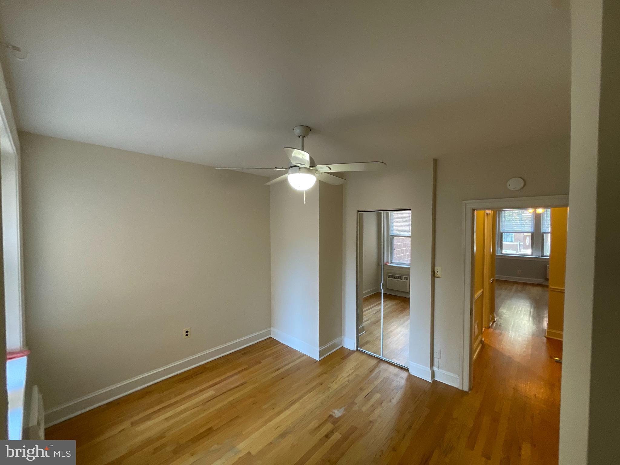 1820 Swann Street Northwest, Unit 101 Washington, DC 20009 - Photo 5 of 15 a view of empty room with wooden floor and fan