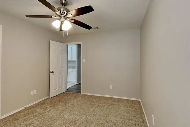 an empty room with closet and windows
