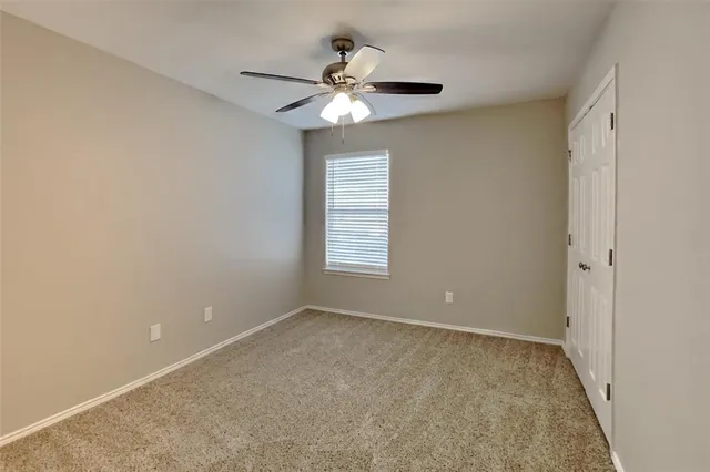 an empty room with a fan and a fan