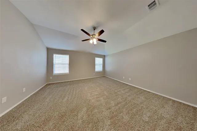 a view of a room with windows and chandelier fan