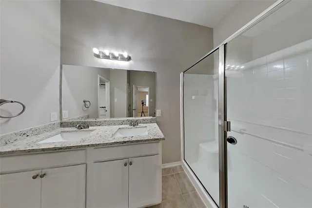 an empty room with ceiling fan and windows