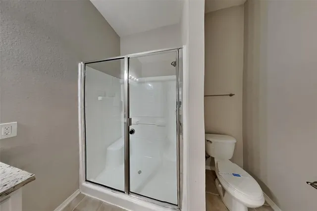 a bathroom with a granite countertop sink a mirror and a shower
