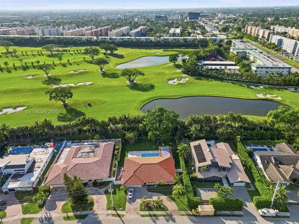 an aerial view of a city with lots of residential buildings ocean and mountain view in back