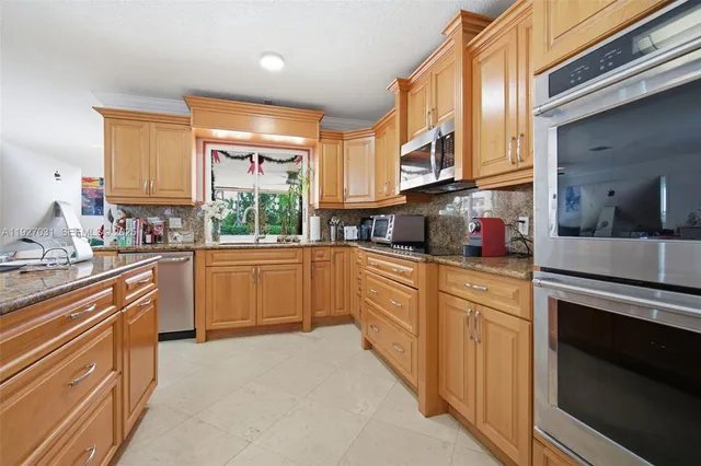 a kitchen with stainless steel appliances a sink window and cabinets