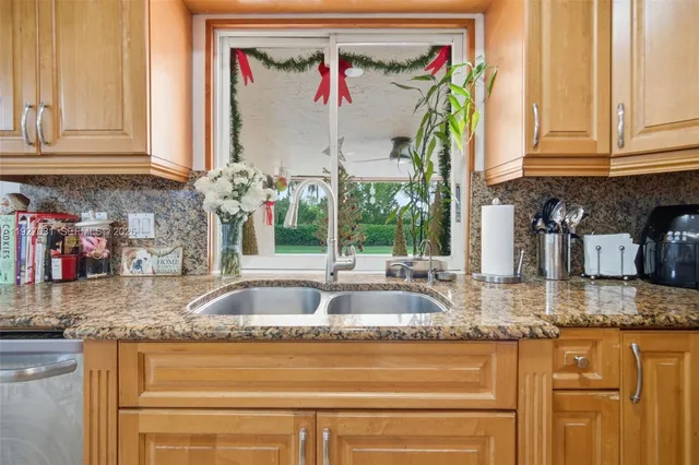a kitchen with granite countertop a sink and a window