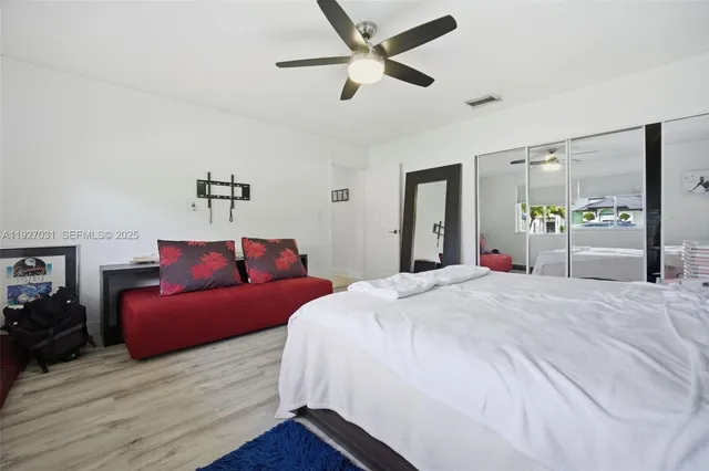 a bedroom with a bed and wooden floor