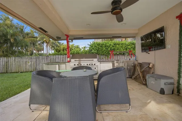 a view of a patio with couches chairs potted plants and floor to ceiling window