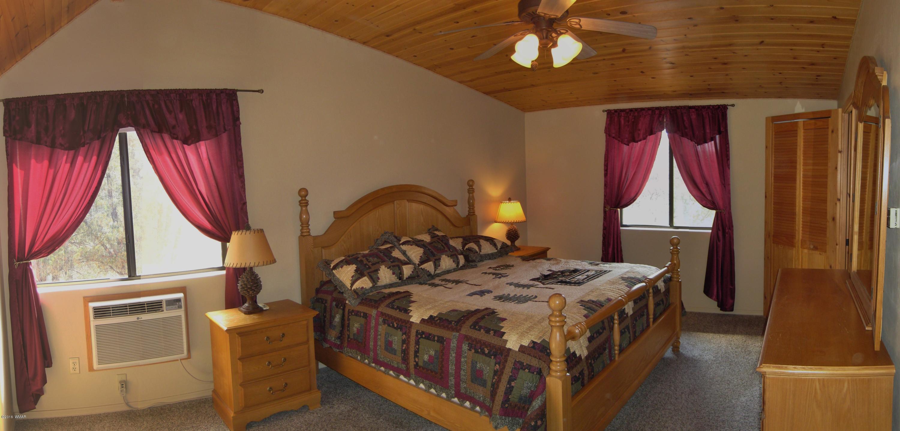 2845 Markham Road Overgaard, AZ 85933 - Photo 22 of 56 a bed sitting in a bedroom next to a window