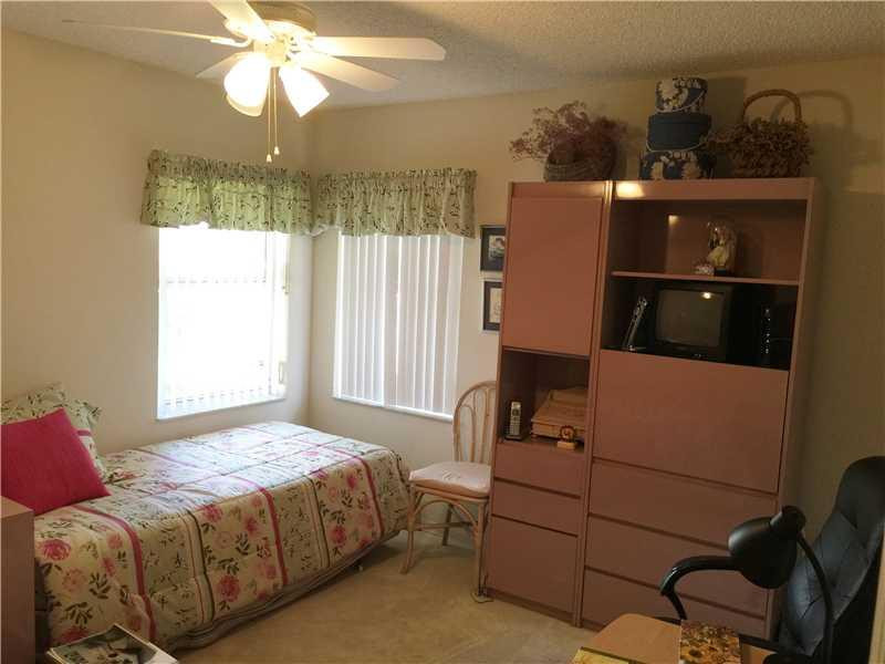 11096 Rios Road, Unit 11096 Boca Raton, FL 33498 - Photo 23 of 35 a bedroom with a bed and a chandelier