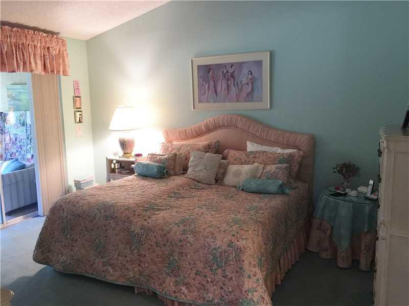 11096 Rios Road, Unit 11096 Boca Raton, FL 33498 - Photo 8 of 35 a bedroom with a bed and a painting on the wall