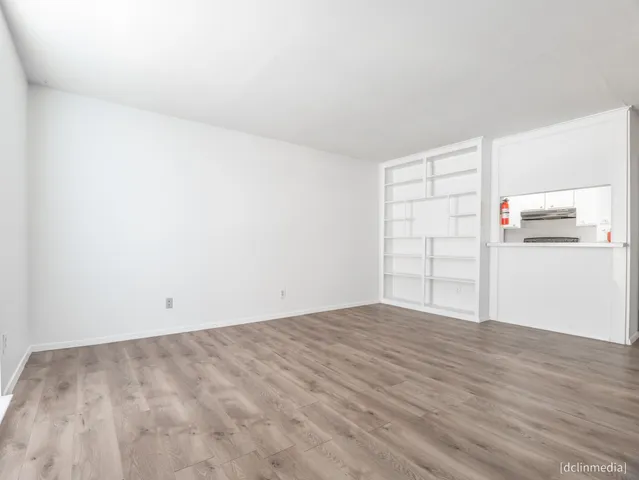 a view of empty room with wooden floor