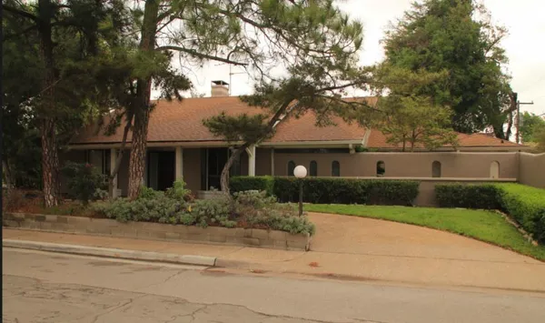 a front view of a house with a yard and potted plants