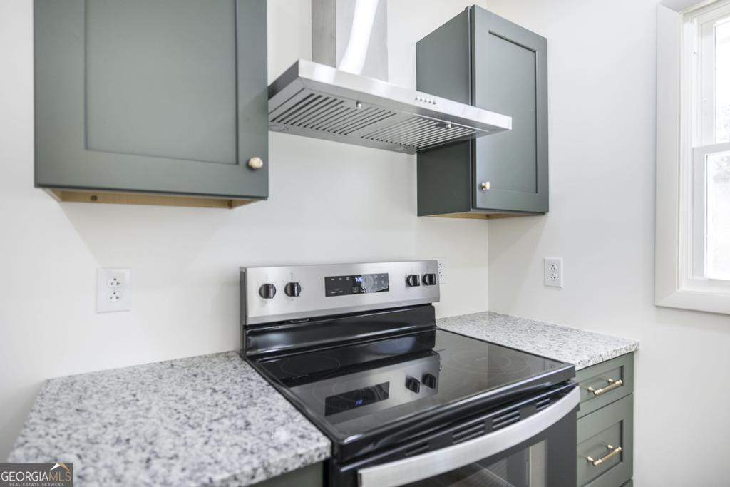103 Spring Street Warner Robins, GA 31088 - Photo 15 of 30 a kitchen with wooden cabinets and a stove top oven